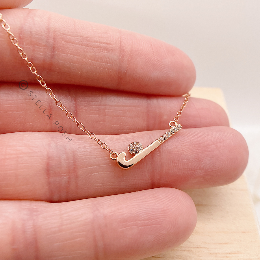 Dainty .925 Sterling Silver Field Hockey Necklace with premium cubic zirconias in a pavé setting, held in hand for scale.