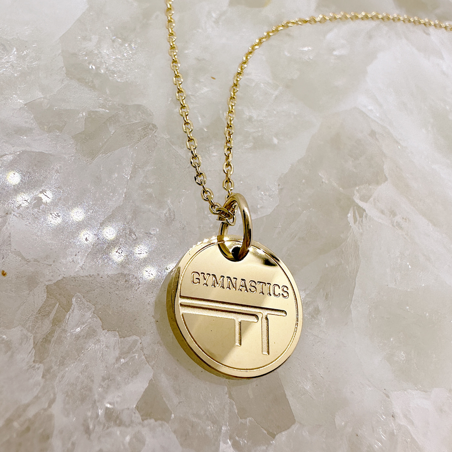 Gold gymnastics disc charm necklace.