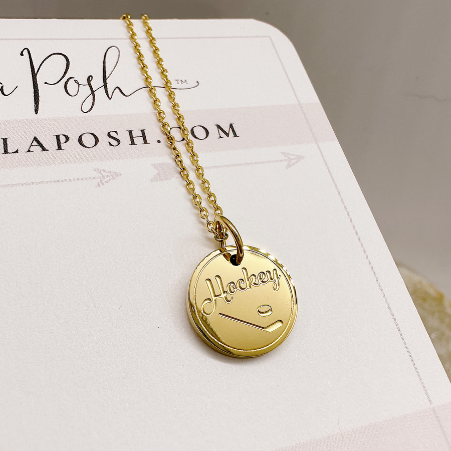 Gold hockey disc charm necklace.
