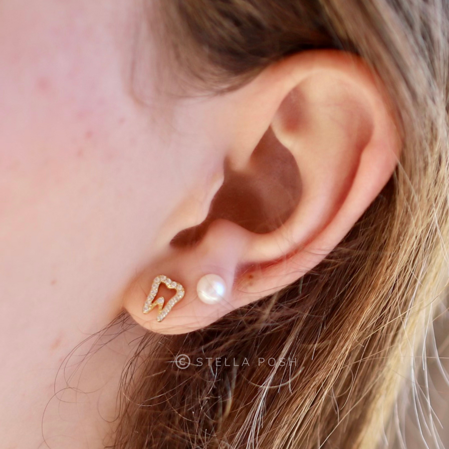 Model wearing layered earrings with Tiny Tooth .925 Sterling Silver Earrings with premium cubic zirconia stones in a pavé setting.