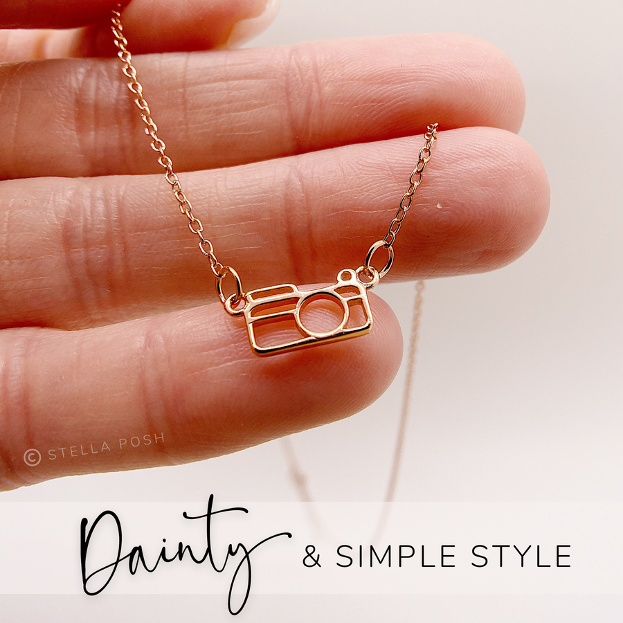 Dainty .925 silver Camera Necklace in gold, held in hand for scale.