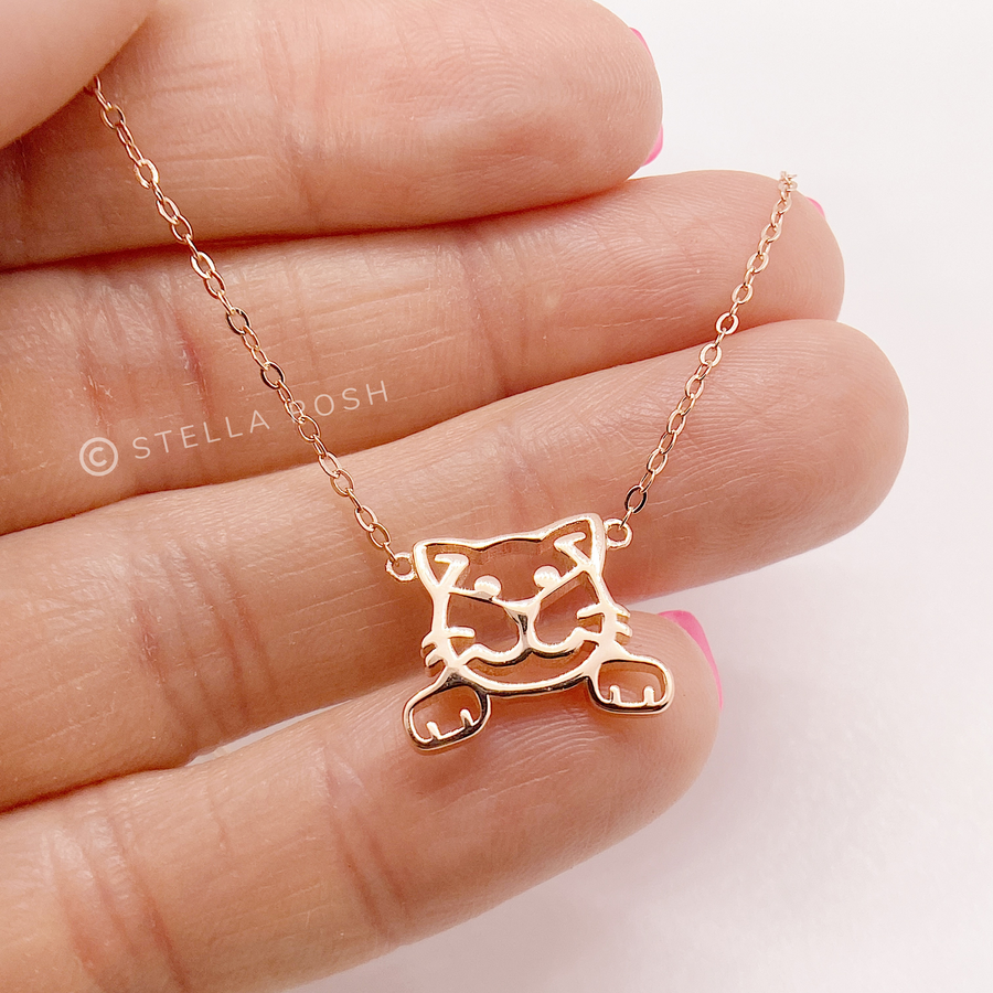 Dainty Cat .925 Sterling Silver necklace in gold, held in hand for scale.
