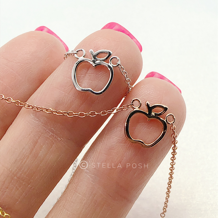 Beautiful and dainty .925 sterling silver Apple Necklaces in silver and gold, held in hand for scale.
