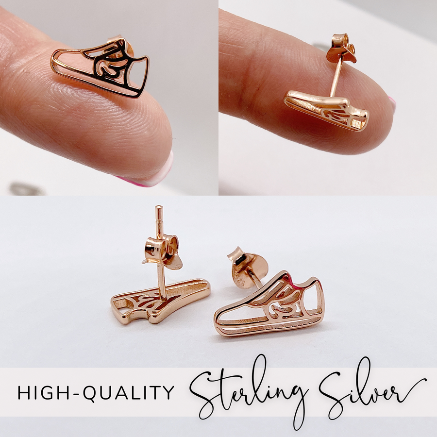 Dainty .925 Sterling Silver Running Shoe Earrings in 14K Gold, Rose Gold, or Rhodium plated, held on finger for scale.