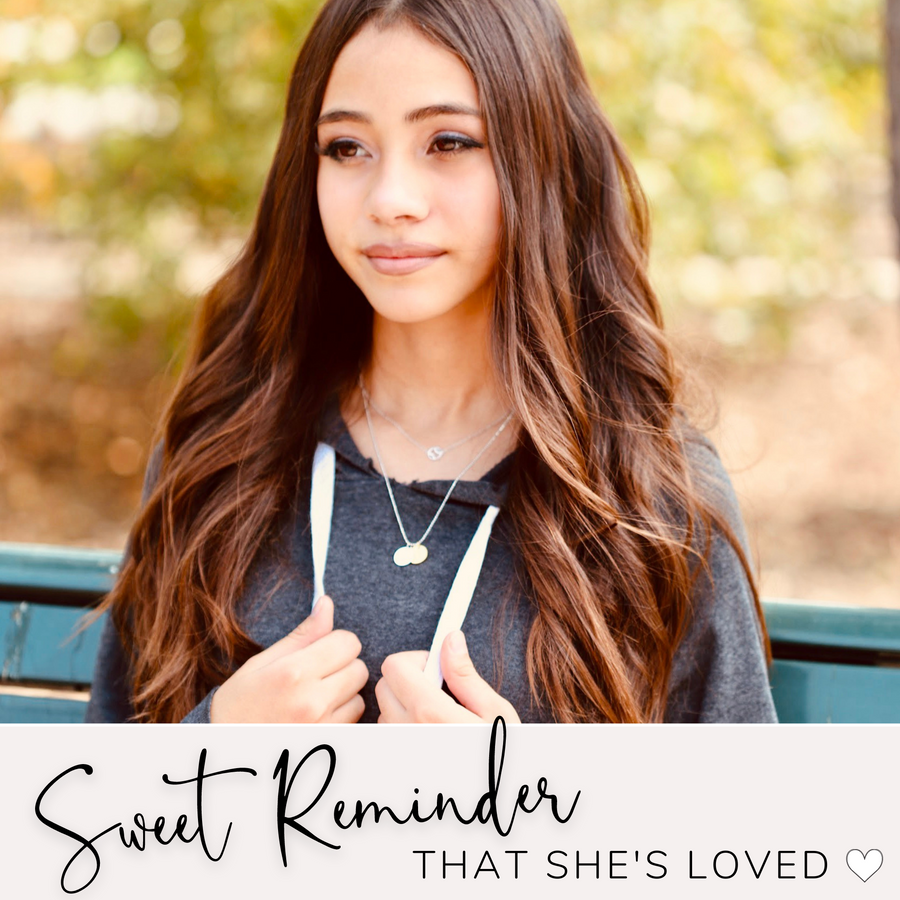 Model wearing Dainty Hockey Charm Necklace with 'Hockey' charm, and 'She believed she could so she did' charm, layered with .925 silver necklace, a sweet reminder that she's loved.