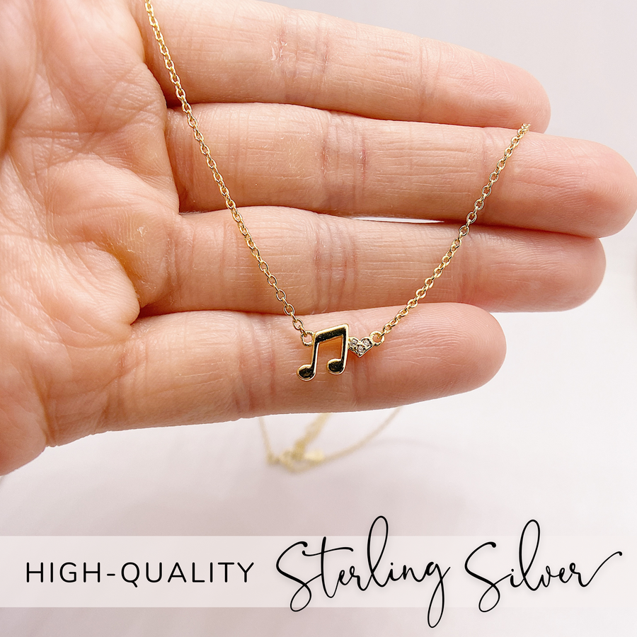 .925 silver Music Note  Necklace with premium cubic zirconias, held in hand for scale.