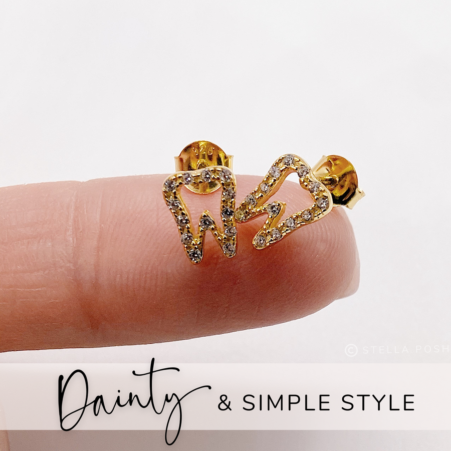 Tiny .925 Sterling Silver Tooth Earrings with premium cubic zirconia stones in a pavé setting, shown on finger for scale.