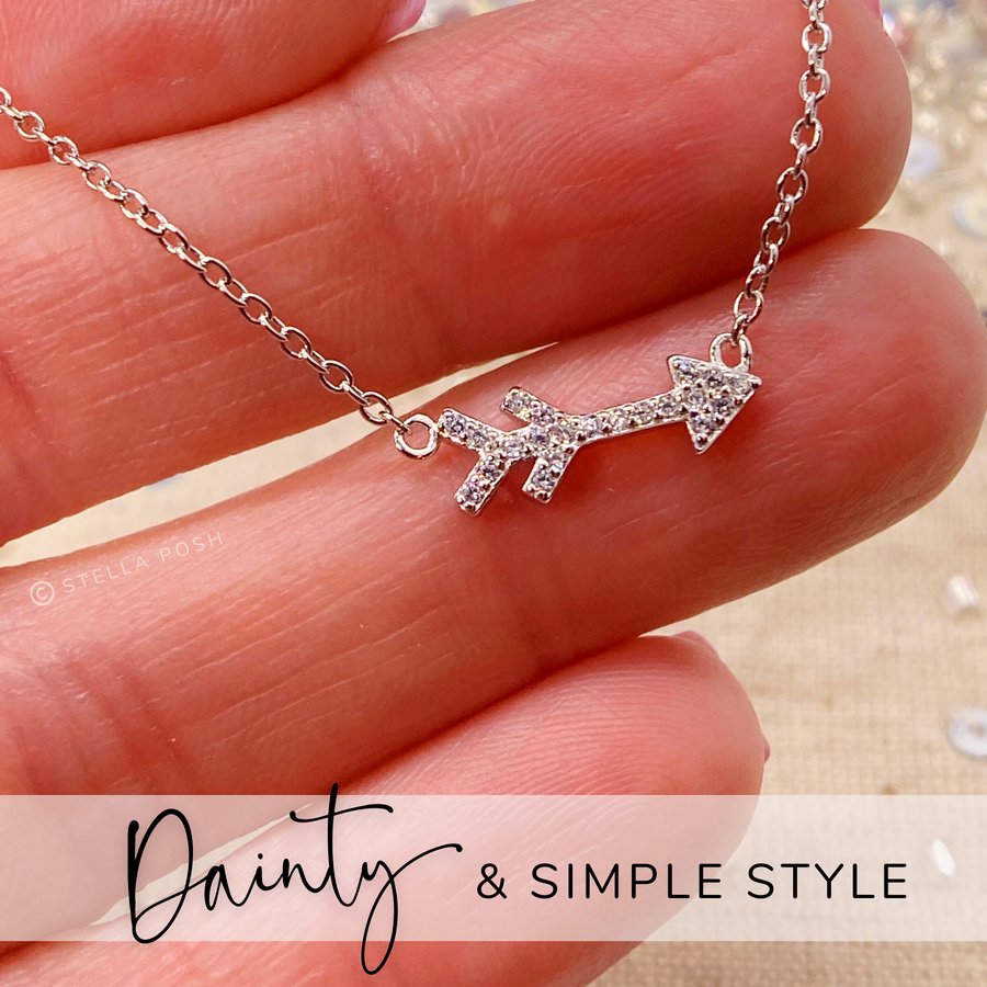 Dainty Arrow .925 Sterling Silver necklace with premium cubic zirconias in a pavé setting, held in hand for scale.