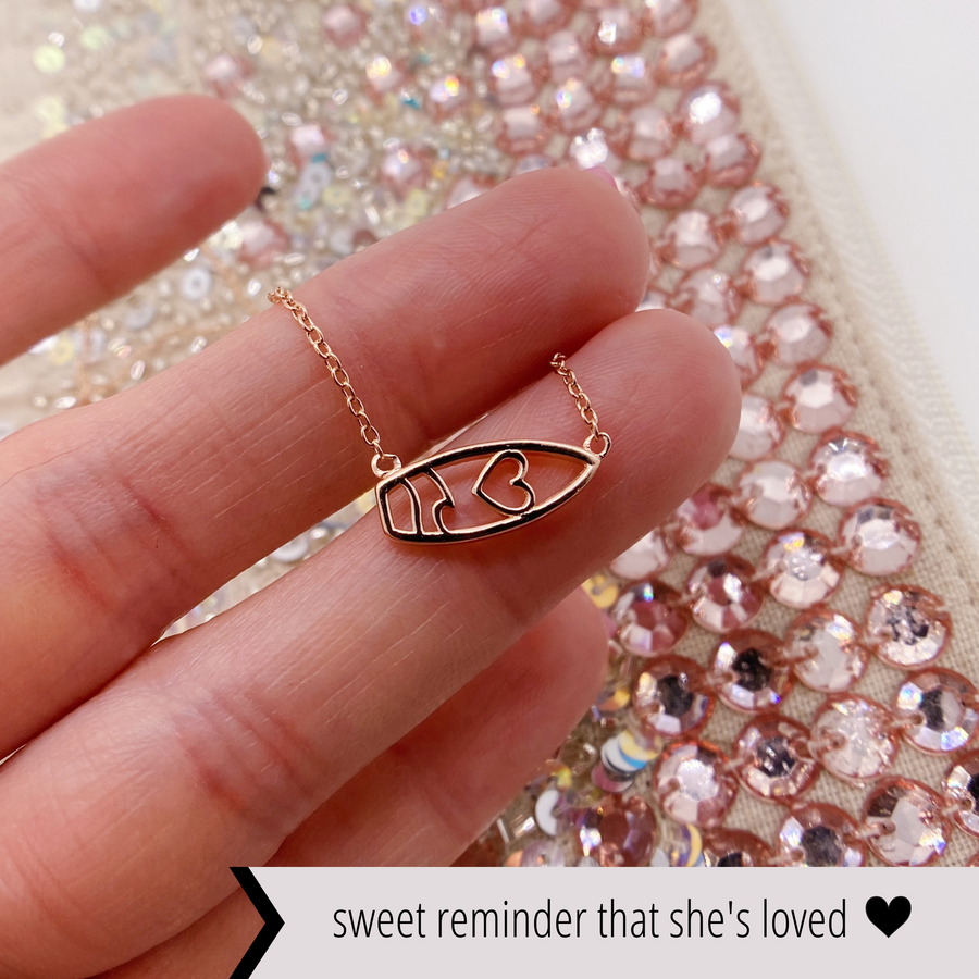 .925 silver Surfboard Necklace in rose gold, held in hand for scale.
