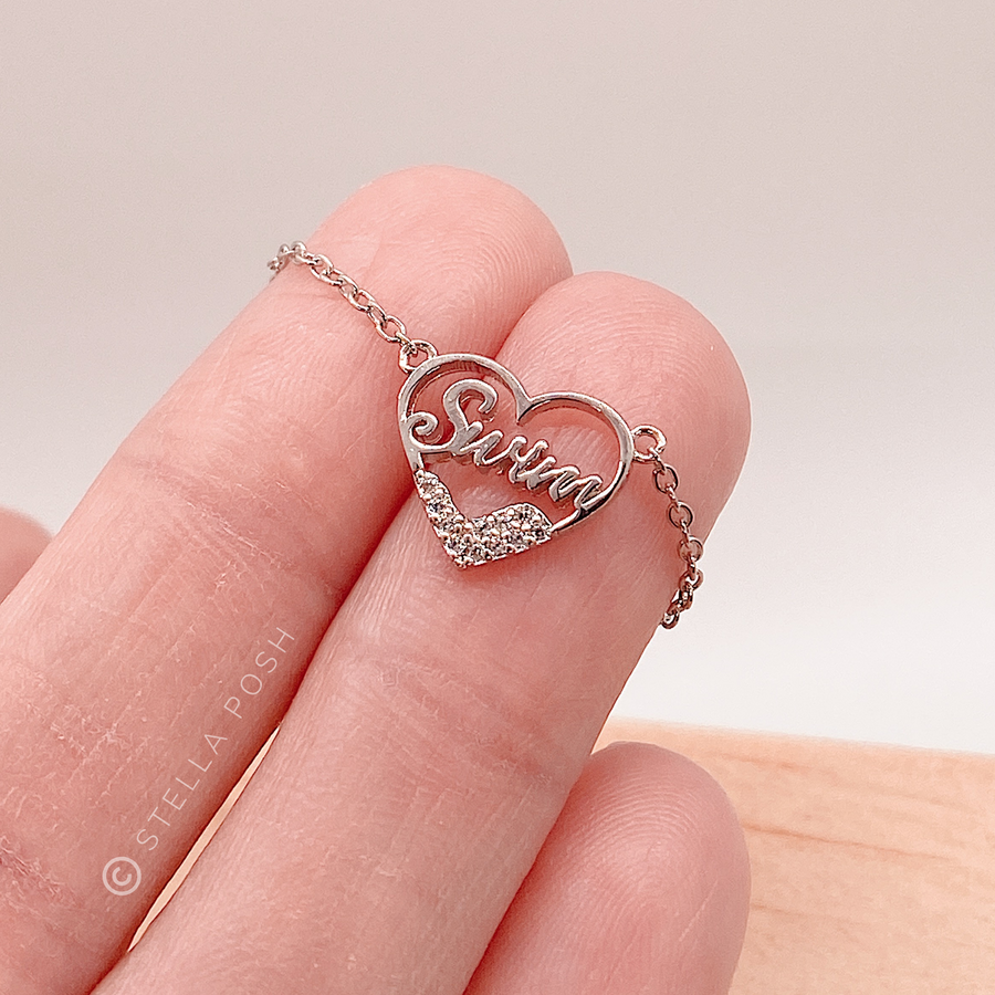 Dainty .925 silver Swim Necklace in gold with premium cubic zirconias, held in hand for scale.