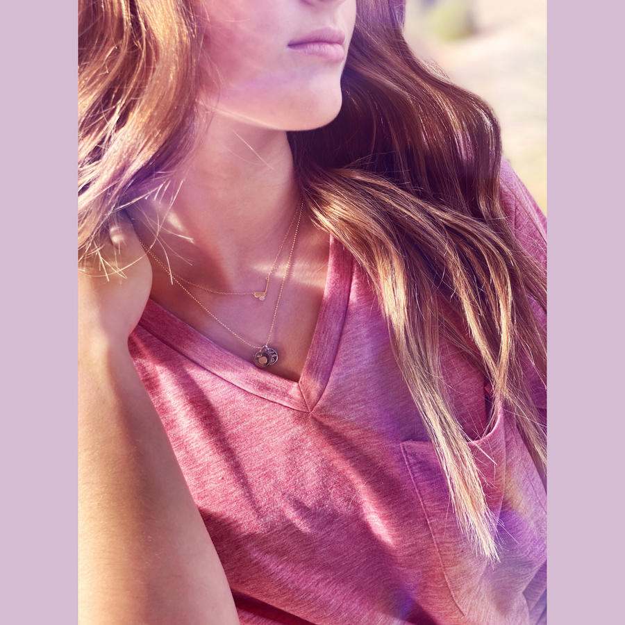 Model wearing .925 silver Tiny Golf Necklace with tiny premium cubic zirconias, and layered with a Charm Necklace.